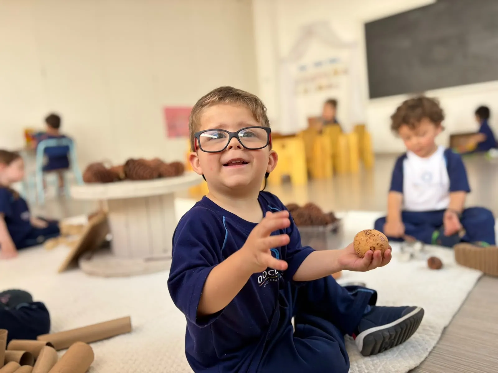 Criança explorando materiais naturais em uma atividade sensorial na escola